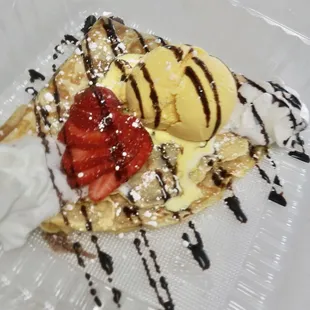 a waffle with ice cream, strawberries, and chocolate sauce