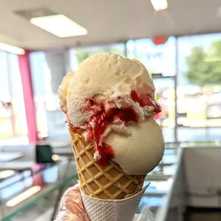 a hand holding a cone of ice cream