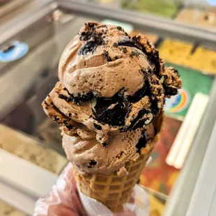 a hand holding a cone of ice cream