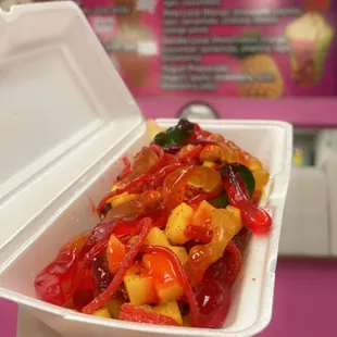 a hand holding a container of food