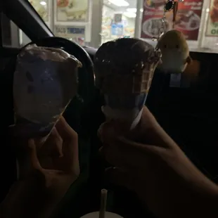 two hands holding ice cream cones