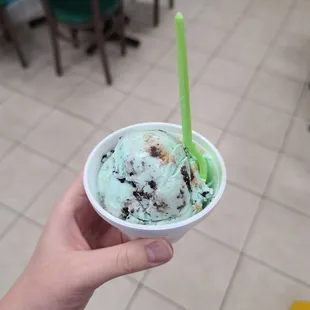a hand holding a cup of ice cream