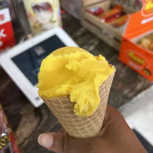 Mango (non dairy) ice cream in a waffle cone.