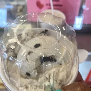 a hand holding a bowl of ice cream