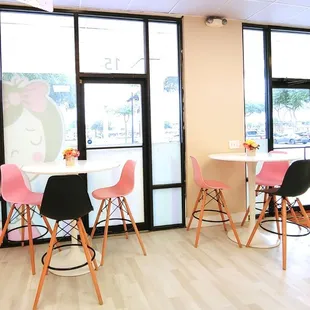 tables and chairs in front of large windows