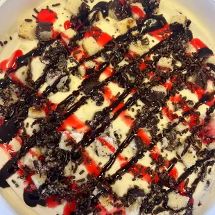 a bowl of ice cream with chocolate and strawberries