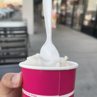 a hand holding a cup of ice cream