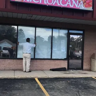 a man standing in front of a restaurant