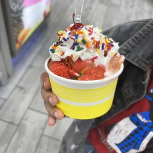 a person holding a cup of ice cream