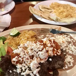 carne asada served with an enchilada and rice and beans. On the far side is my daughters quesadilla and rice she ate all of it!