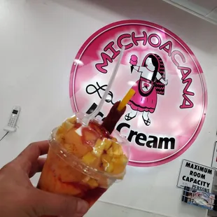 a hand holding a cup of ice cream