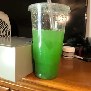a green drink in a plastic cup