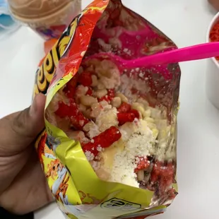 a hand holding a bag of ice cream