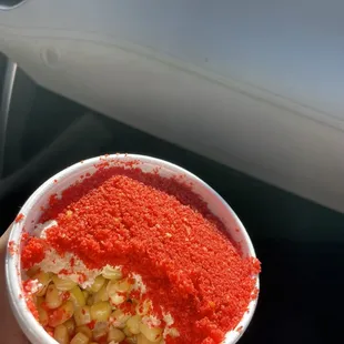 a person holding a bowl of red food