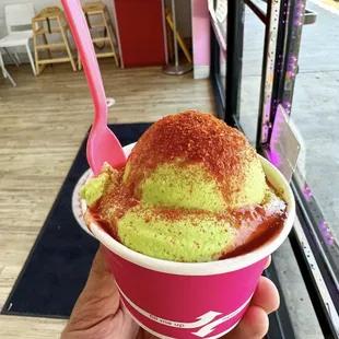 a hand holding a cup of ice cream