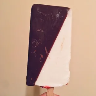 Chocolate dipped vanilla popsicle with strawberry filling