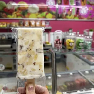 a hand holding a piece of ice cream