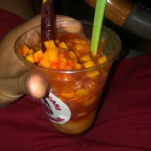 Mangoniada ice cream with mango bits and chamoy and tamarindo stick