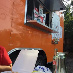 a man sitting at a table in front of a food truck