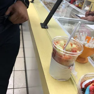  a man standing in front of a counter with a variety of drinks