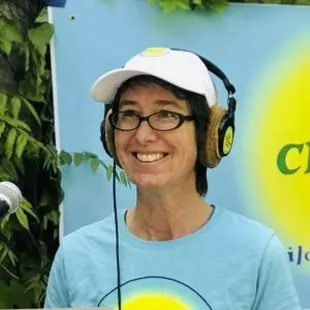 a smiling woman wearing headphones