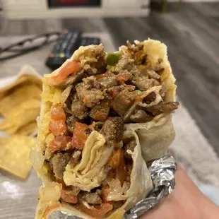 a hand holding a burrito