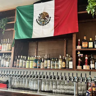 a mexican flag hanging over a bar