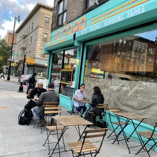 people sitting outside of a restaurant
