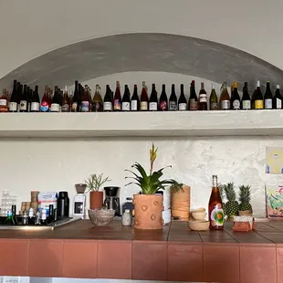 bottles of wine on a shelf above a bar