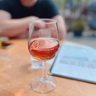 a man sitting at a table with a glass of wine