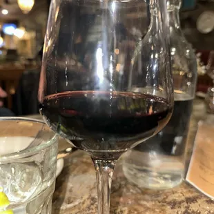 a glass of red wine on a table