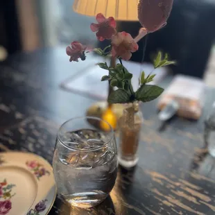 a glass of water with a flower in it