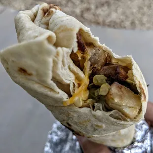 a hand holding a burrito