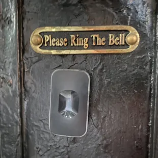 a metal door with a sign that says please ring the bell