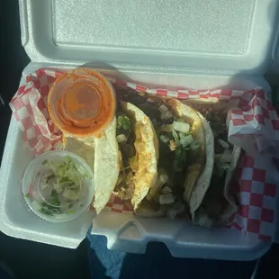 two tacos in a styrofoam container