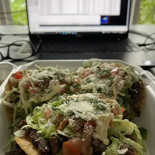 a plate of food with a laptop in the background
