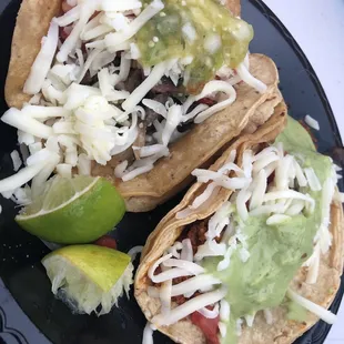 two tacos on a black plate