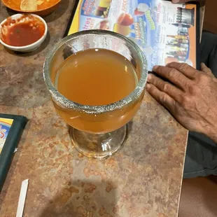 a person sitting at a table with a glass of beer