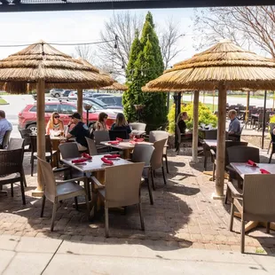 a group of people sitting at tables under umbrellas