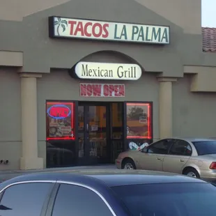 a mexican grill with cars parked in front