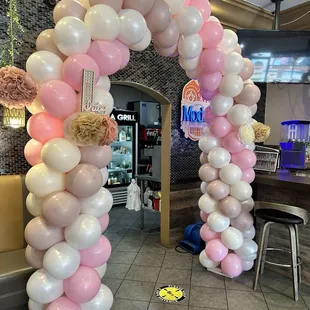 a pink and white balloon arch