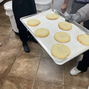 a man holding a tray of cookies