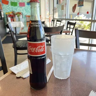 Chilled cup with ice and a bottle coke