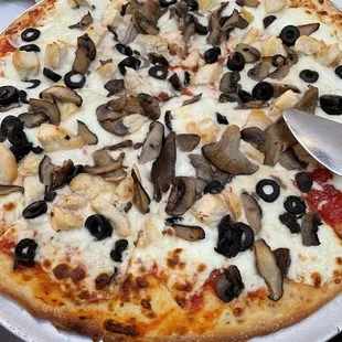 a pizza with mushrooms and black olives