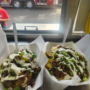two trays of food in front of a window