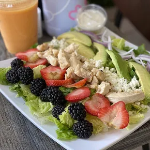 a plate of salad with fruit and avocado