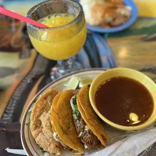a plate of tacos and a glass of orange juice
