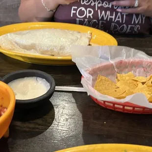 Chips, Salsa, and white sauce ( my wife in the background ) My wife ordered the California Burrito!