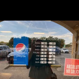 a business hours sign in a window