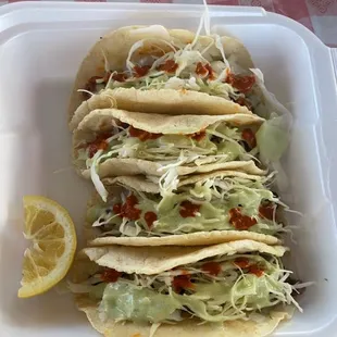 three tacos in a styrofoam container